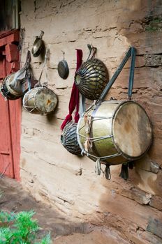 Old traditional indian drums on wooden wet wall, focus on the big drum