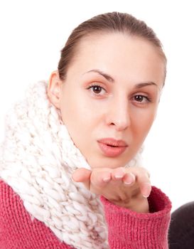 Beautiful young woman in winter scarf blow kisses on white background