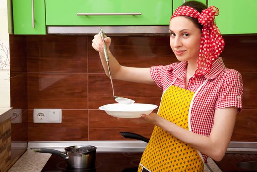 Beautiful happy smiling cooking woman in kitchen interior