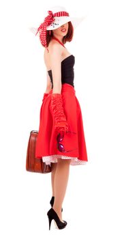 Full-length girl in retro style with suitcase and big hat on white background