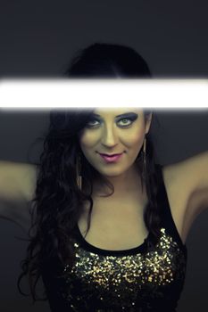 View of a beautiful girl in dark leather clothes holding a light tube.