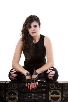 View of a beautiful girl in dark leather clothes against a white background holding a large retro radio.