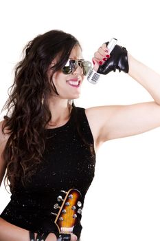 View of a beautiful girl in dark leather clothes against a white background holding a microphone.