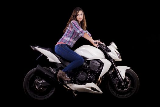 View of a beautiful young girl next to a white motorbike in a studio environment. 