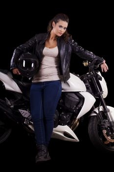 View of a beautiful young girl next to a white motorbike in a studio environment. 