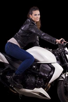 View of a beautiful young girl next to a white motorbike in a studio environment. 