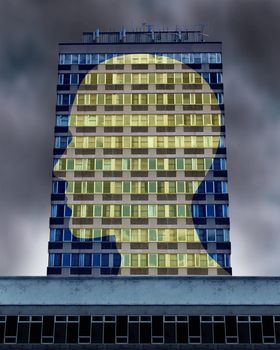 Illuminated mind with a commercial building as windows with the light turned on forming a profile of a human head as a symbol of life and health also education with a bright future.