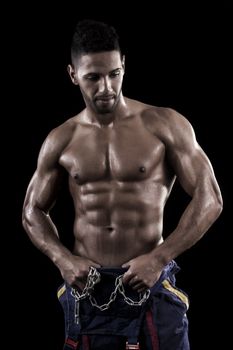 View of a muscled man on a black background in artistic, fitness and bodybuilding poses.