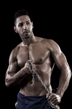 View of a muscled man on a black background in artistic, fitness and bodybuilding poses.