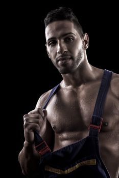 View of a muscled man on a black background in artistic, fitness and bodybuilding poses.