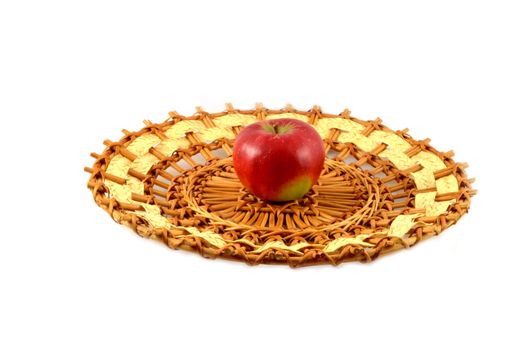 ripe red apple on a wattled plate from a rod