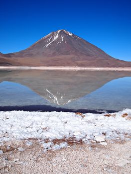 Reflection of Licancabur volcano in Laguna Verde (green lagoon) in the desert near Uyuni in Bolivia.