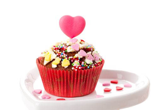 Cupcake with heart candy on top, isolated on white