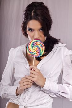 View of a beautiful girl with a colorful lollipop. 