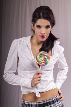 View of a beautiful girl with a colorful lollipop. 