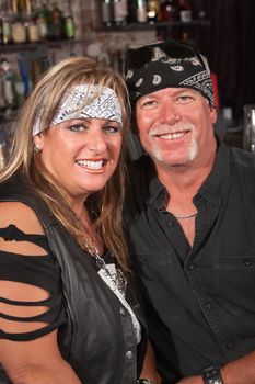 Handsome middle aged couple in leather and bandanna in bar