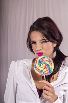 View of a beautiful girl with a colorful lollipop. 