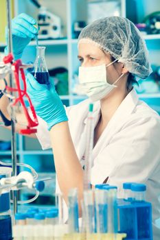 Scientific researcher holding at a liquid solution in a lab