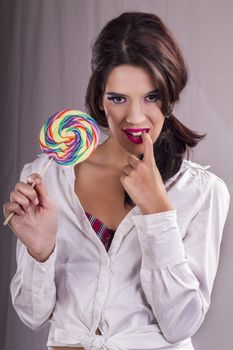 View of a beautiful girl with a colorful lollipop. 