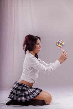 View of a beautiful girl with a colorful lollipop. 
