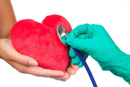 A doctor with stethoscope examining red heart, isolated on white