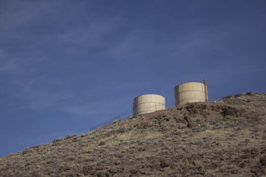 two water tanks on a mountain side