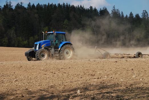 Tractor is ploughing a field after the summer