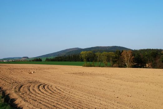 Freshly ploughed filed in the spring and a rural landscape