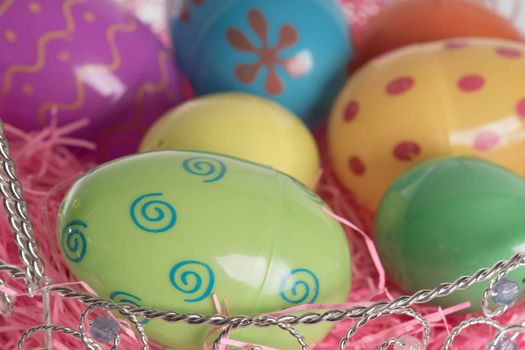 Decorated Easter eggs in Easter basket with pink decorative grass.  Isolated on white background.