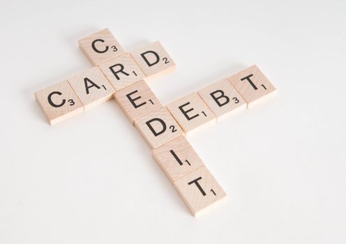 "Credit Card Debt" concept spelled in Scrabble letters. Isolated on white background.