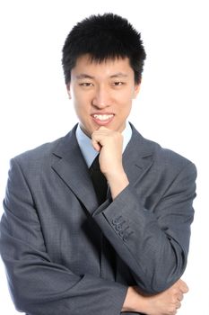 Thoughtful Asian businessman in a suit standing facing the camera with his hand to his chin isolated on white