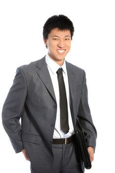 Confident relaxed Asian businessman standing with a folder under his arm and his hand in his pocket smiling at the camera isolated on white