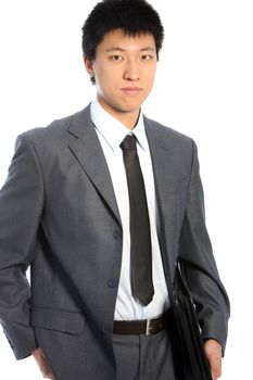 Serious asian businessman in gray suit posing on white background