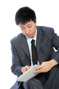 Serious young businessman working on his tablet isolated on white