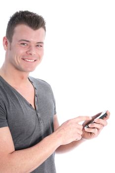 Smiling young man looking at the camera using a smartphone entering information with his finger on the touchscreen isolated on white