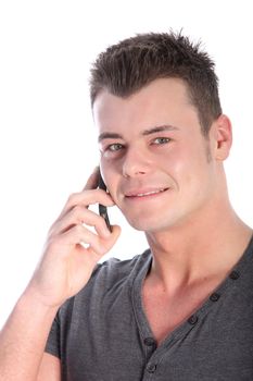 Young man using a smartphone or mobile phone looking thoughfully at the camera as he listens and waits for his call to connect isolated on white