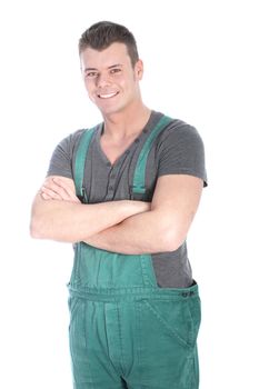 Smiling confident muscular young handyman or labourer in dungarees standing with his arms folded looking at the camera isolated on white