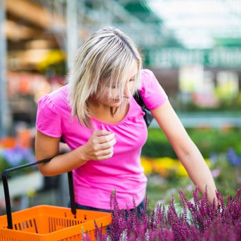 Young woman buying flowers at a garden center