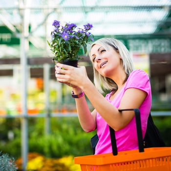 Young woman buying flowers at a garden center