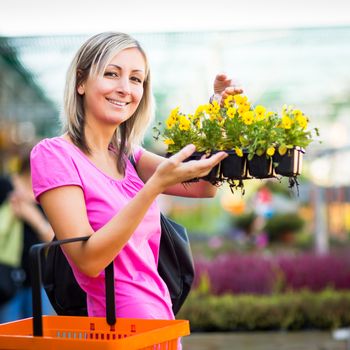 Young woman buying flowers at a garden center