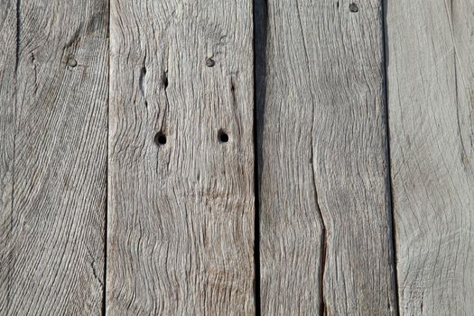 Planks of sun bleached oak with grain, joints, holes and cracks.