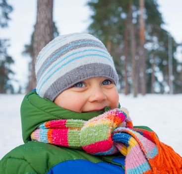 Portrait of a little baby boy in winter forest.