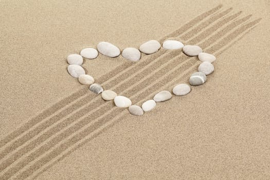 handwritten heart on yellow soft sand with seashell 