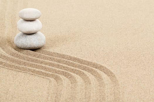Balance of three zen stones in sand 