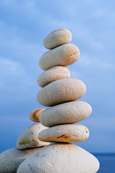 Balancing of white pebbles on the sea coast