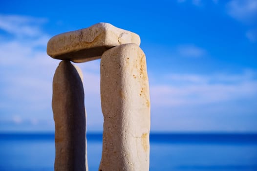 Balancing of three white pebbles on the sea coast
