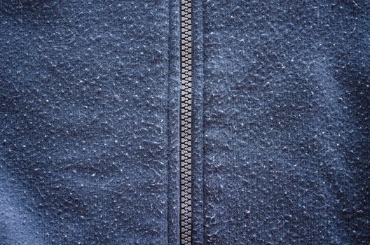 jumper robe garment zipper zipped and well worn fabric background closeup.