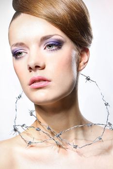 Young woman with barbed wire around her throat. Сoncept