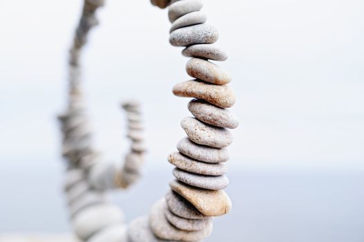 White spiral of pebbles on a sky background blur