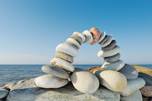 Balancing of white pebbles on the seashore